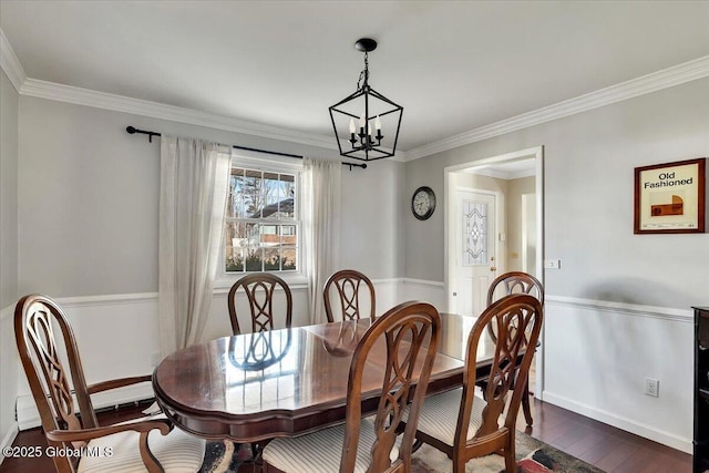 dining space featuring crown molding, dark wood-type flooring, and an inviting chandelier