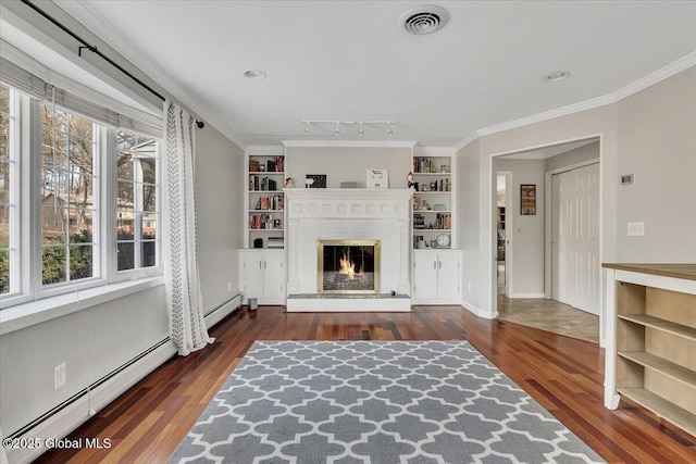 unfurnished living room with a baseboard heating unit, a glass covered fireplace, a healthy amount of sunlight, and visible vents