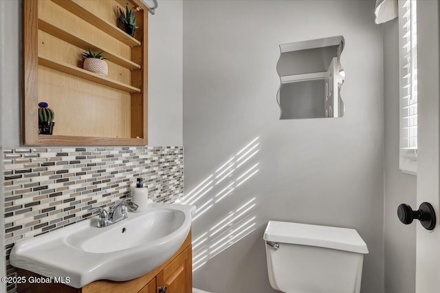 bathroom featuring backsplash, vanity, and toilet