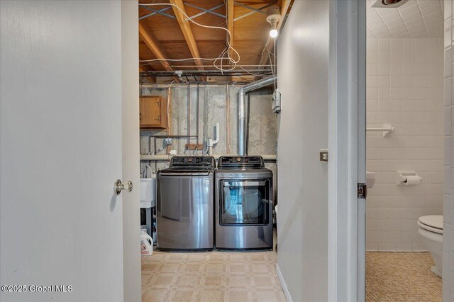 washroom featuring light floors, laundry area, and washer and clothes dryer