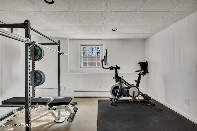 workout area featuring a drop ceiling and baseboards