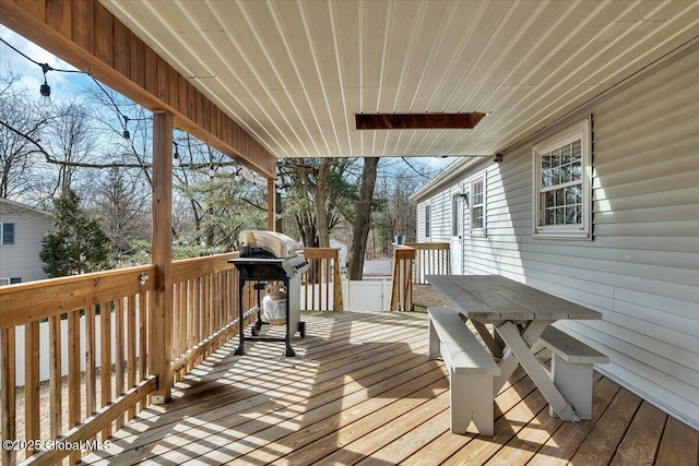 wooden terrace featuring grilling area and outdoor dining area