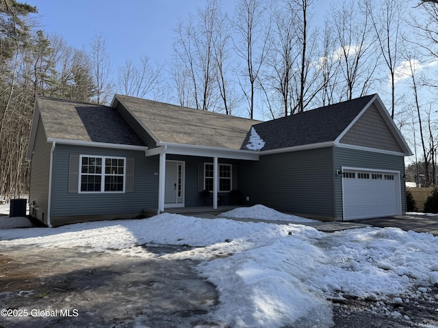 view of front facade with a garage, central AC unit, and covered porch