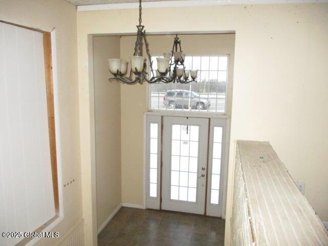 entryway featuring a chandelier, a healthy amount of sunlight, and baseboards