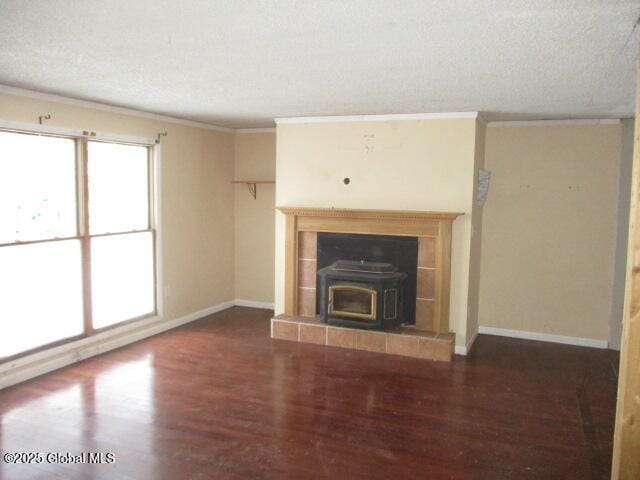 unfurnished living room featuring a textured ceiling, wood finished floors, and ornamental molding