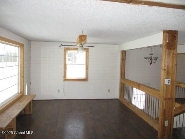 unfurnished room with a textured ceiling and wood finished floors