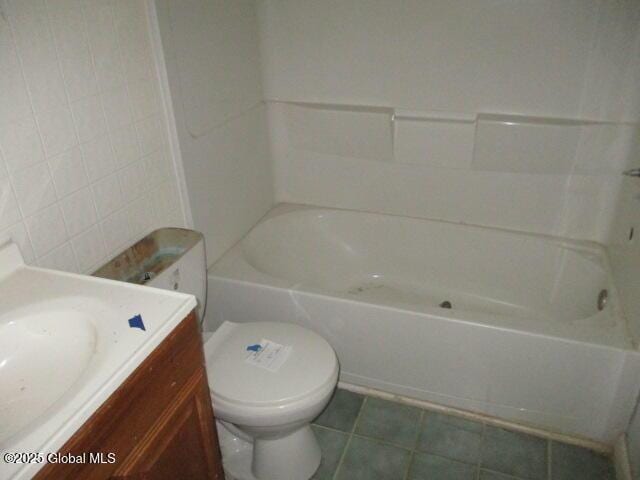 bathroom with tile patterned flooring, toilet, vanity, and tile walls