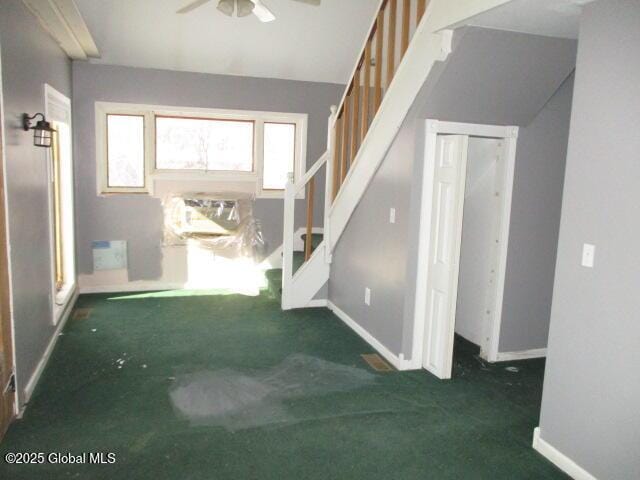 foyer with stairway, baseboards, carpet, and ceiling fan