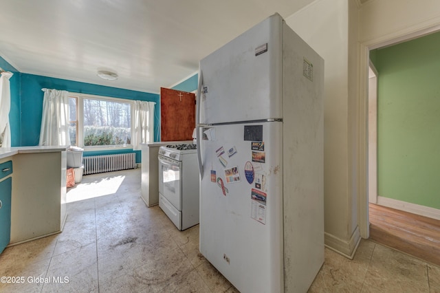 kitchen with baseboards, white appliances, and radiator heating unit