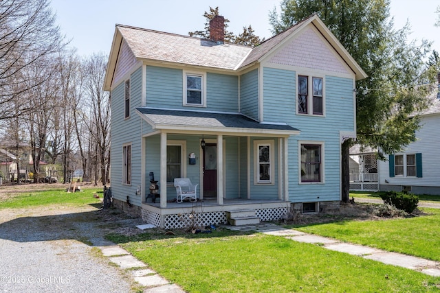 view of front of house with a porch, a front lawn, and a chimney
