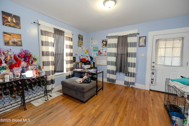 living area with baseboards and hardwood / wood-style flooring