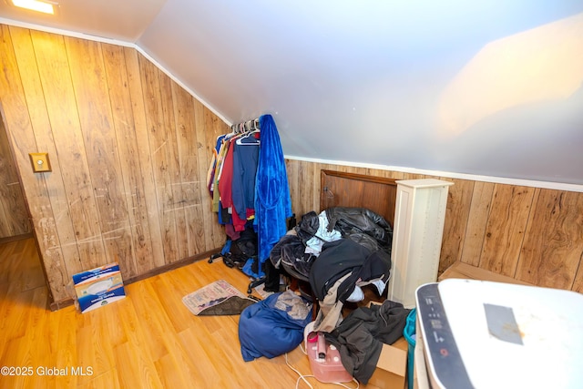 additional living space with wooden walls, wood finished floors, and vaulted ceiling