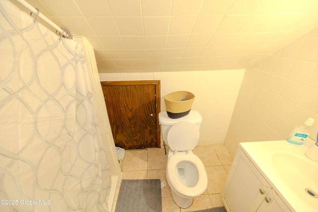 full bathroom with vanity, tile patterned flooring, curtained shower, tile walls, and toilet