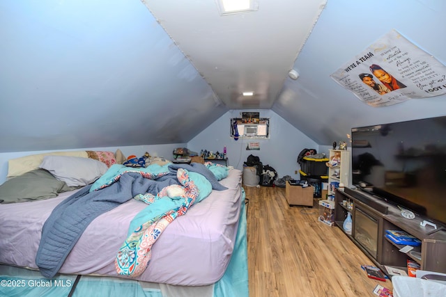 bedroom with lofted ceiling and wood finished floors