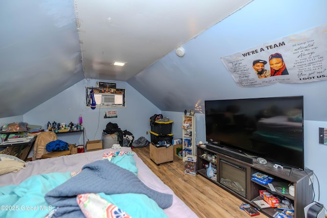 bedroom featuring lofted ceiling and wood finished floors