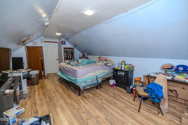 bedroom featuring a closet, vaulted ceiling, and wood finished floors