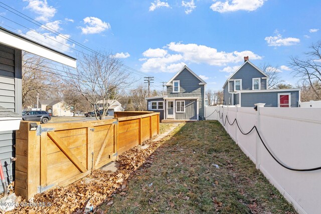 view of yard featuring an outdoor structure, fence private yard, and a gate