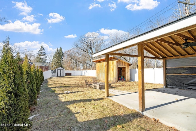 view of yard featuring an outdoor structure, a fenced backyard, a shed, and a patio