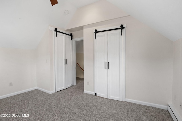 bonus room featuring a barn door, vaulted ceiling, carpet flooring, and a baseboard radiator