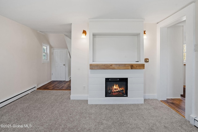 unfurnished living room with a glass covered fireplace, carpet flooring, and baseboard heating