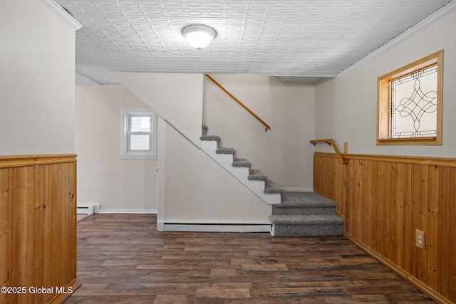 stairway featuring crown molding, wood finished floors, baseboard heating, and a baseboard radiator