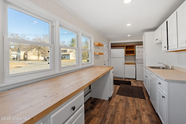 kitchen featuring dark wood-type flooring, a sink, white cabinetry, white appliances, and butcher block counters