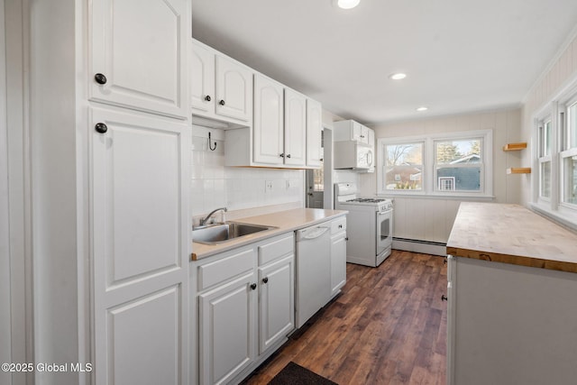 kitchen with a sink, a baseboard radiator, white appliances, and white cabinetry