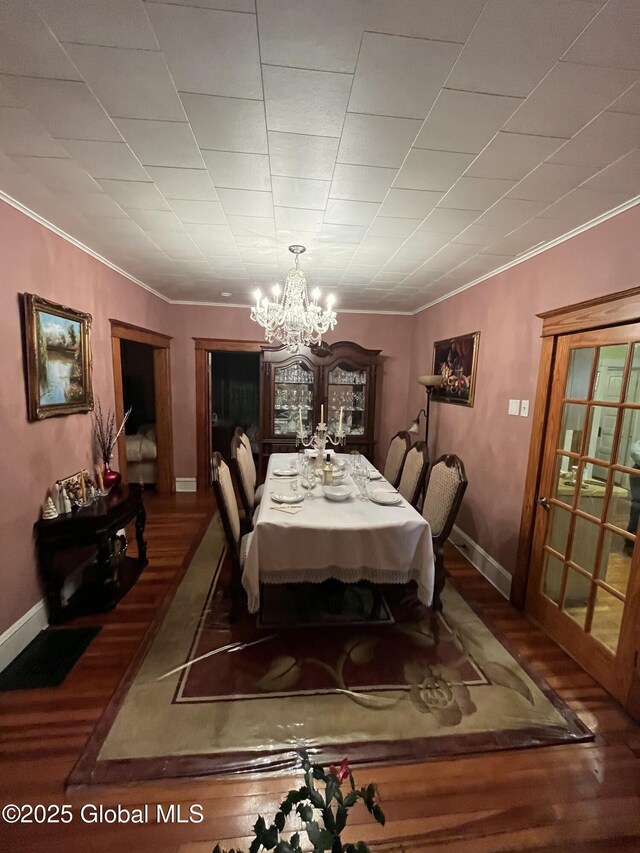 dining room with baseboards, wood finished floors, and ornamental molding