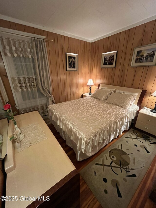 bedroom with wooden walls and wood finished floors