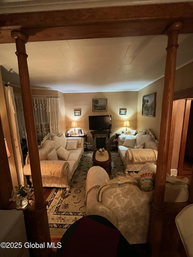living room featuring a fireplace and decorative columns