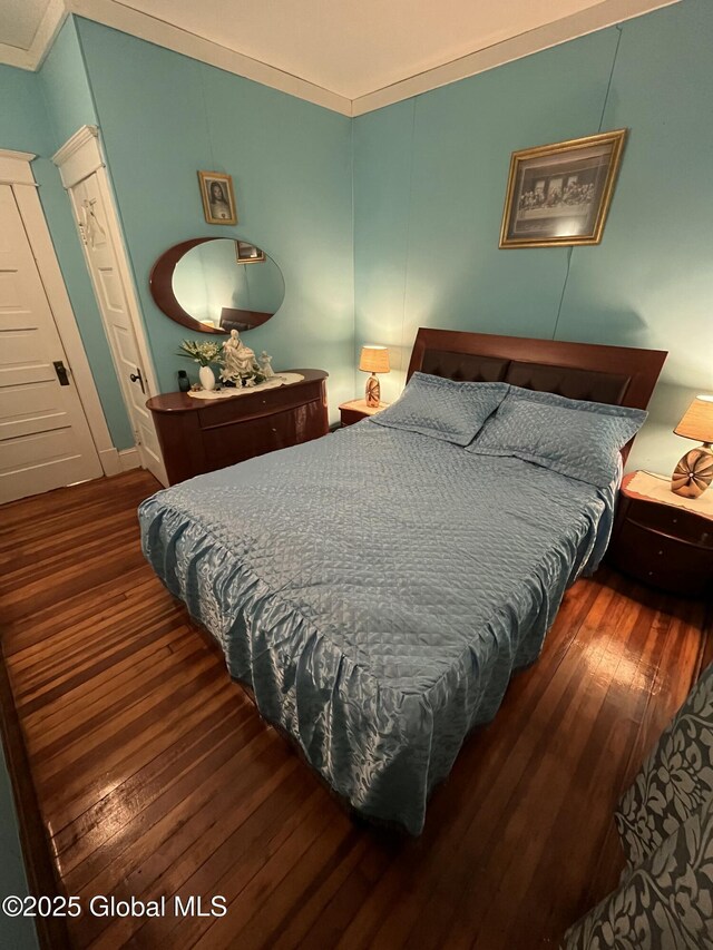 bedroom with hardwood / wood-style flooring and crown molding