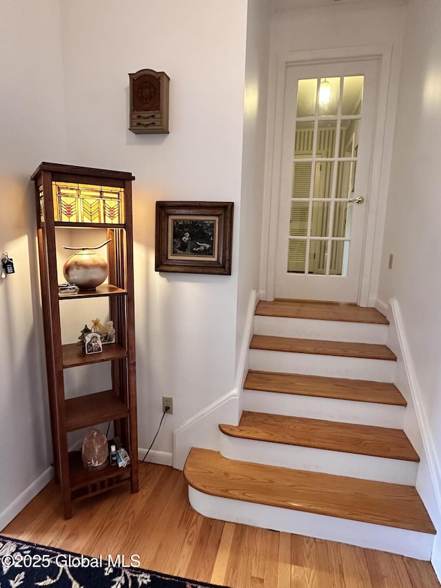stairway with baseboards and wood finished floors