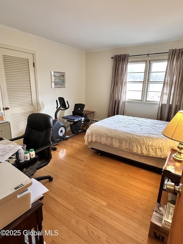 bedroom featuring crown molding and wood finished floors