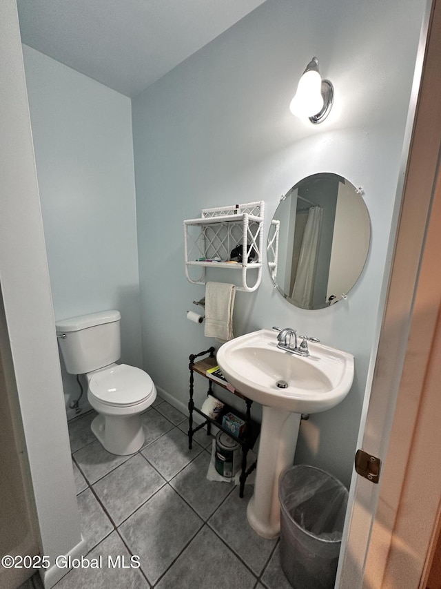 full bath with tile patterned floors, baseboards, toilet, and a sink