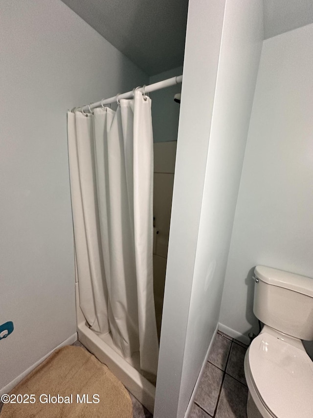 full bath with tile patterned floors, toilet, and a shower stall