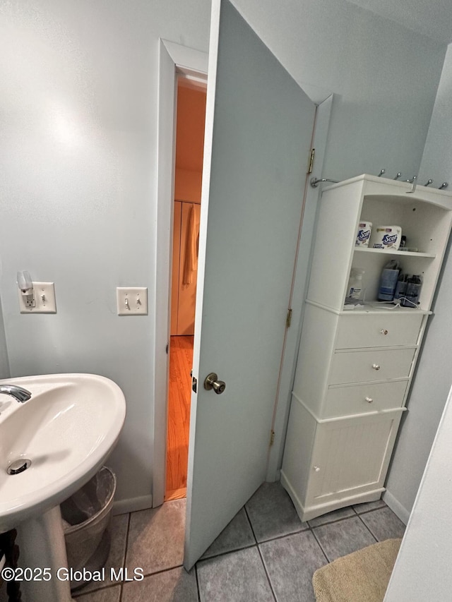 bathroom featuring tile patterned floors, baseboards, and a sink
