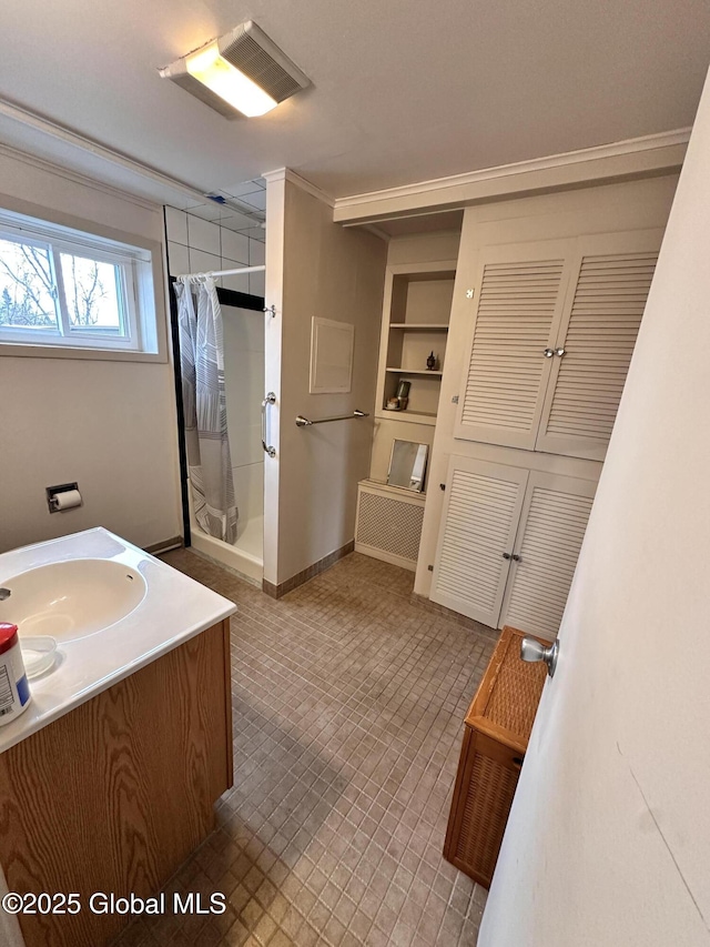 bathroom featuring vanity, a shower with shower curtain, baseboards, visible vents, and ornamental molding