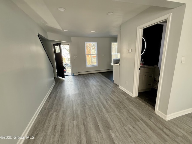 interior space featuring wood finished floors, baseboards, and baseboard heating