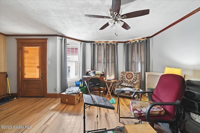 interior space featuring a ceiling fan, wood finished floors, crown molding, and a textured ceiling