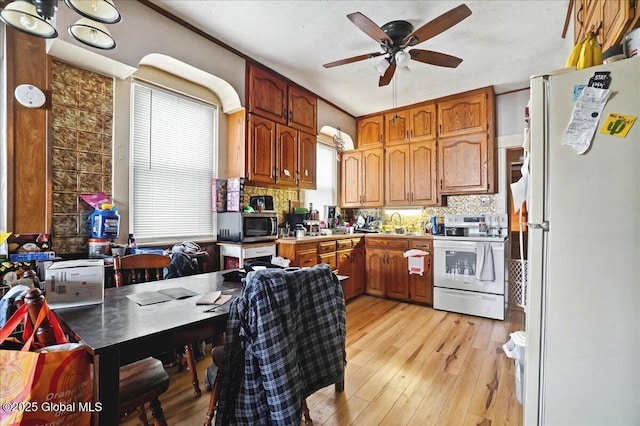 kitchen with decorative backsplash, white appliances, light wood-type flooring, and ceiling fan