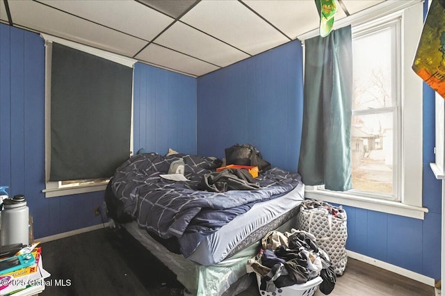 bedroom featuring a paneled ceiling and wood finished floors