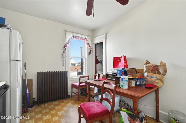 dining room with light floors, radiator, and a ceiling fan