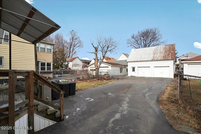 exterior space featuring a garage, an outbuilding, and fence