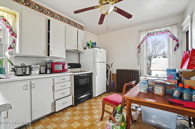 kitchen with range with electric stovetop, radiator heating unit, freestanding refrigerator, light countertops, and light floors