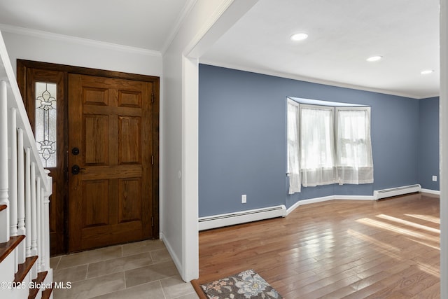 foyer entrance with stairs, crown molding, wood finished floors, and baseboard heating