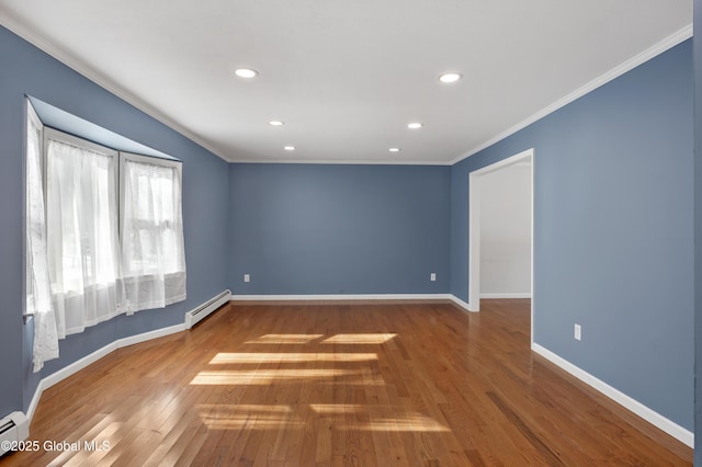 spare room with ornamental molding, hardwood / wood-style flooring, baseboards, and a baseboard radiator