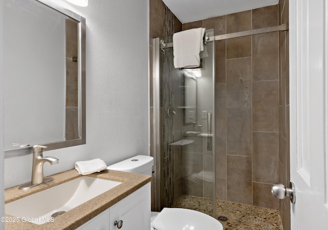 bathroom featuring a shower stall, toilet, and vanity