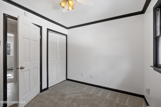 unfurnished bedroom featuring a closet, baseboards, carpet, and ornamental molding