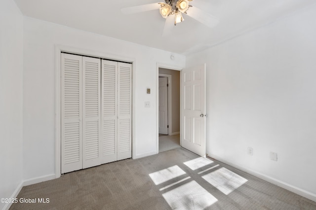 unfurnished bedroom featuring a closet, baseboards, carpet, and a ceiling fan