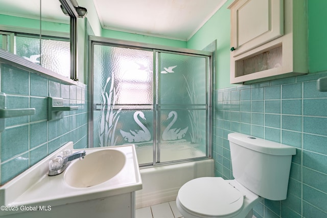 bathroom with vanity, ornamental molding, tile walls, toilet, and combined bath / shower with glass door